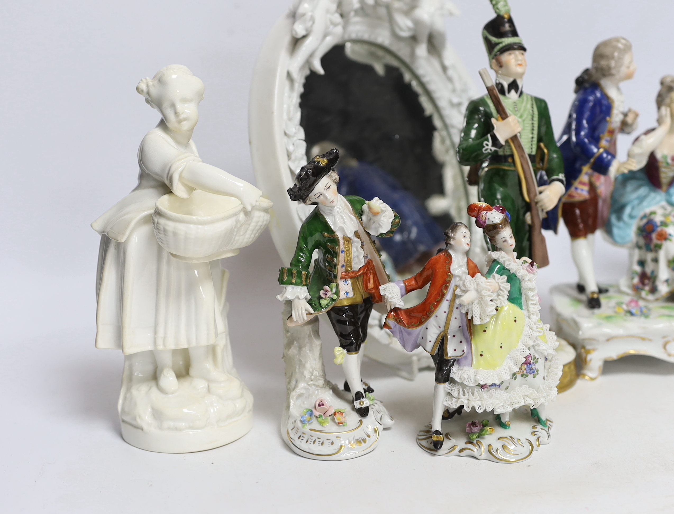 Seven Continental porcelain figures and an oval mirror with floral encrusted decoration, 27cm high